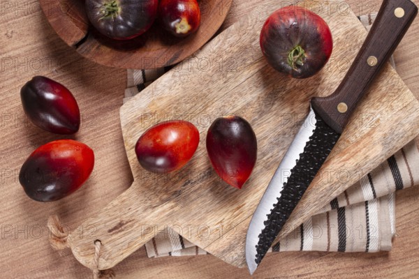 Sliced tomatoes, Black Beauty variety, on a cutting board, top view, on the kitchen table