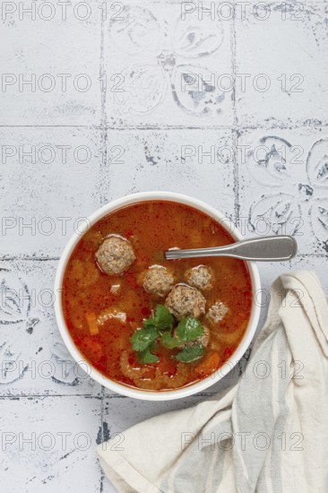 Romanian soup with meatballs, vegetable soup with meatballs, tiled table, homemade, no people