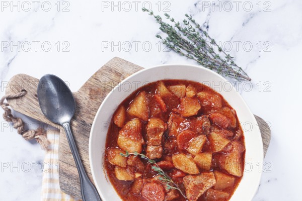 Meat goulash with potatoes and carrots, sweet peppers, in a saucepan, top view, traditional Hungarian soup, homemade, no people