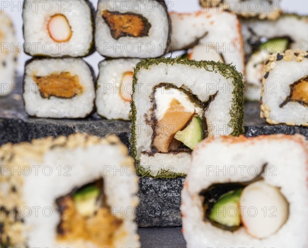 Various sushi dishes on dark grey stone surface