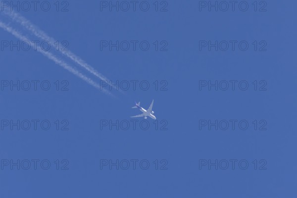 Airbus A300-600RF jet aircraft of FedEx Express airlines in flight in a blue sky with vapour trails or contrails behind, England, United Kingdom