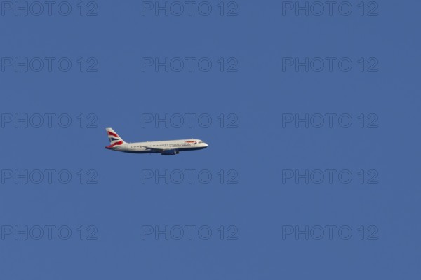 Airbus A320-232 jet passenger aircraft of British Airways airlines in flight in a blue sky, London, England, United Kingdom
