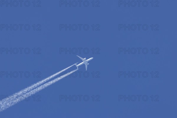 Boeing 787-9 Dreamliner jet passenger aircraft of KLM Royal Dutch airlines in flight in a blue sky with vapour trails or contrails behind, England, United Kingdom