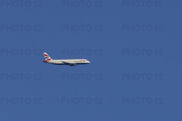 Airbus A320-232 jet passenger aircraft of British Airways airlines in flight in a blue sky, London, England, United Kingdom
