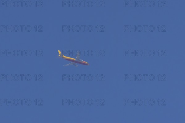 Boeing 767 jet aircraft of DHL cargo airlines in flight in a blue sky, England, United Kingdom