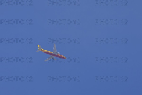 Boeing 767 jet aircraft of DHL cargo airlines in flight in a blue sky, England, United Kingdom