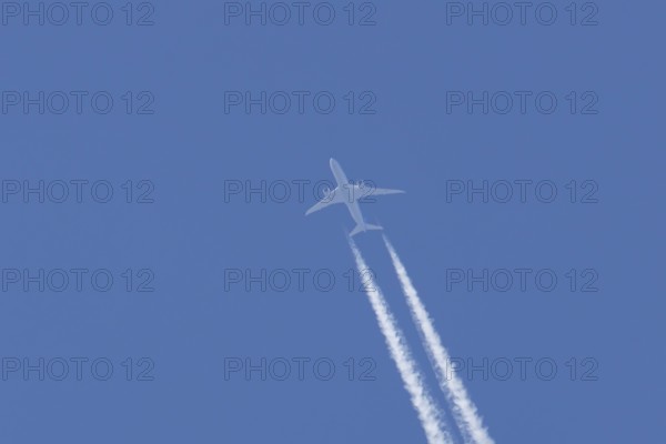 Boeing 787-9 Dreamliner jet passenger aircraft of KLM Royal Dutch airlines in flight in a blue sky with vapour trails or contrails behind, England, United Kingdom