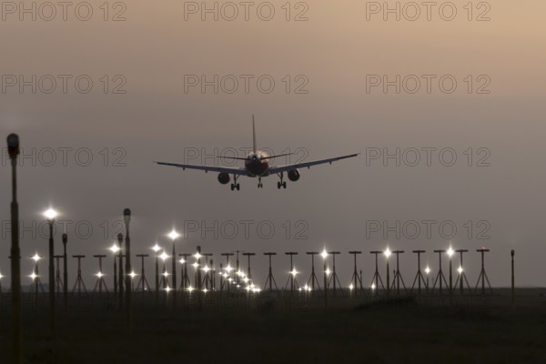 Airbus jet passenger aircraft in flight landing at sunset at London Stansted airport, Essex, England, United Kingdom