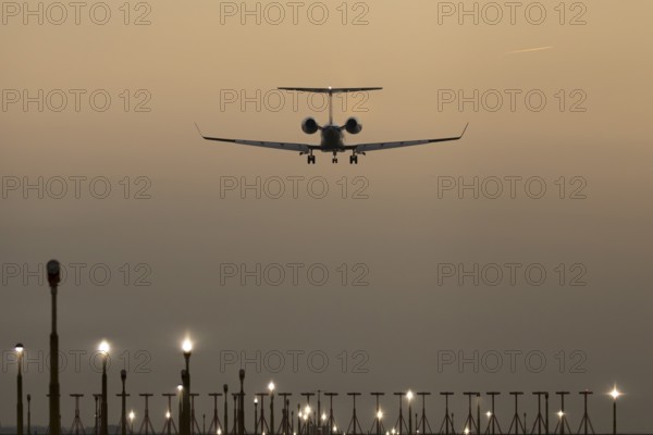Bombardier Global business jet passenger aircraft in flight landing at sunset at London Stansted airport, Essex, England, United Kingdom