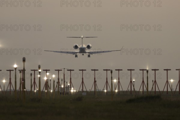 Bombardier Global business jet passenger aircraft in flight landing at sunset at London Stansted airport, Essex, England, United Kingdom