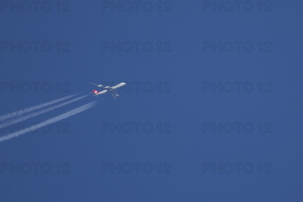 Boeing 747 Jumbo jet cargo aircraft of Cargolux airlines in flight in a blue sky with vapour trails or contrails behind, England, United Kingdom