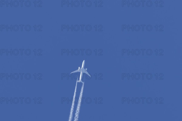 Boeing 787-9 Dreamliner jet passenger aircraft of KLM Royal Dutch airlines in flight in a blue sky with vapour trails or contrails behind, England, United Kingdom