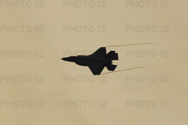 Lockheed Martin F-35 Lightning II fighter military aircraft of the United States air force USAF silhouette in flight at sunset at RAF Lakenheath airbase, Suffolk, England, United Kingdom