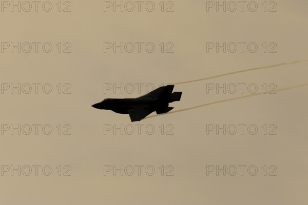 Lockheed Martin F-35 Lightning II fighter military aircraft of the United States air force USAF silhouette in flight at sunset at RAF Lakenheath airbase, Suffolk, England, United Kingdom