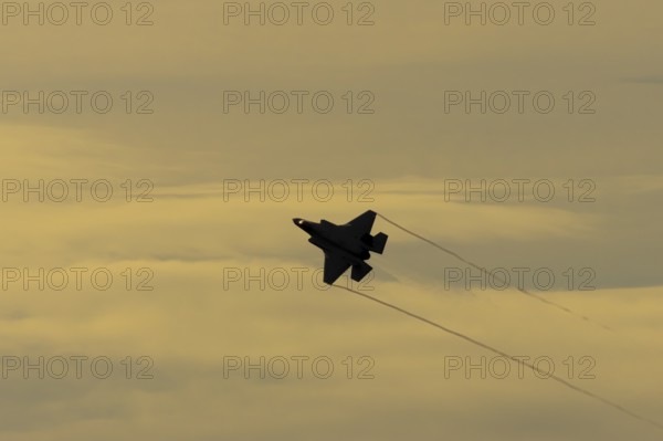Lockheed Martin F-35 Lightning II fighter military aircraft of the United States air force USAF silhouette in flight at sunset at RAF Lakenheath airbase, Suffolk, England, United Kingdom