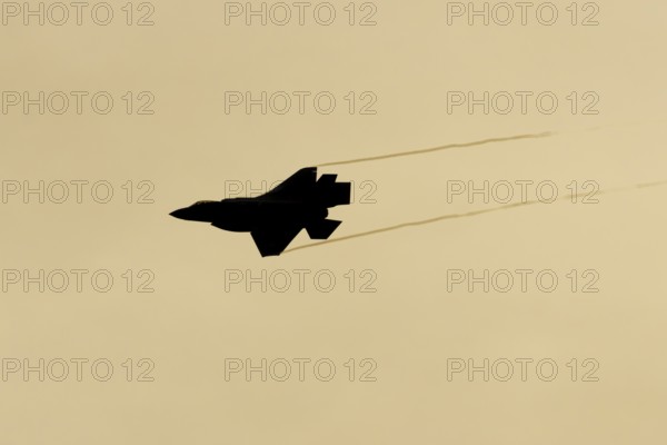 Lockheed Martin F-35 Lightning II fighter military aircraft of the United States air force USAF silhouette in flight at sunset at RAF Lakenheath airbase, Suffolk, England, United Kingdom
