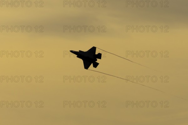 Lockheed Martin F-35 Lightning II fighter military aircraft of the United States air force USAF silhouette in flight at sunset at RAF Lakenheath airbase, Suffolk, England, United Kingdom
