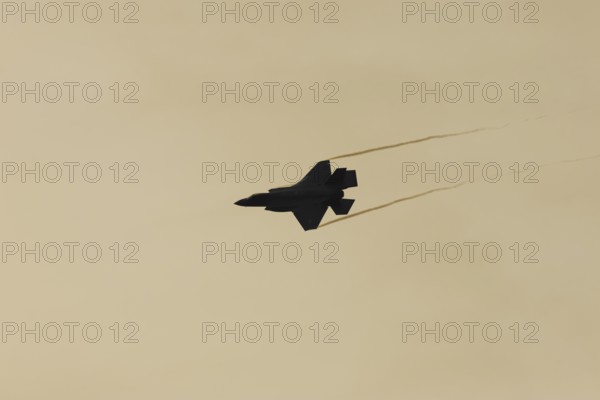 Lockheed Martin F-35 Lightning II fighter military aircraft of the United States air force USAF silhouette in flight at sunset at RAF Lakenheath airbase, Suffolk, England, United Kingdom