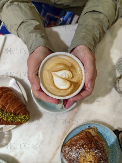 Cappuccino with heart-shaped latte and croissants served on a breakfast table Lower Austria Austria