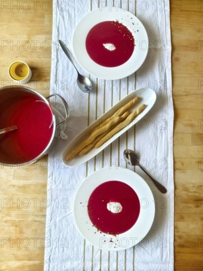 Beetroot soup with cream on a laid table with grissini and candle Lower Austria Austria