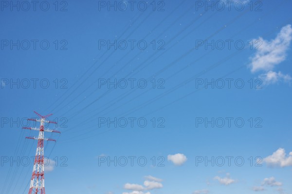 An extremely high electricity electricity electricity pylon, marked white and red, on the banks of the Elbe, river bank, Elbe crossing 2, 227 m high, highest overhead line pylon in Europe, blue sky with small white clouds, cables, lines with red and white marked balls, high-voltage pylon, overhead line pylon, overhead line, colour marking, safety, aviation safety, technology, structure, near Hollern-Twielenfleth, Lühe, Altes Land, Lower Saxony, Germany