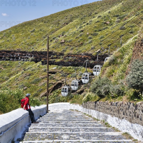 Hiker on stairs, old road to the harbour of the capital Fira, cable car, Thira, Santorini, Cyclades, Greece