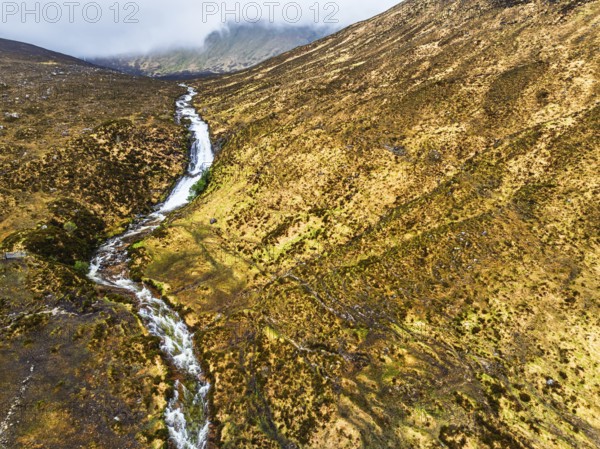 Eas a' Bhradain Waterfall from drone, Red Cuillin mountains, Loch Ainort, Isle of Skye, Scotland, UK