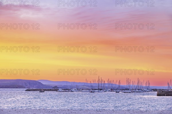 Marina with pleasure boats at a beautiful sunset over the sea and the rocky coastline a summer evening, Crozon peninsula, Bretagne, France