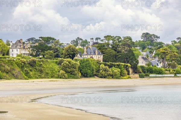 House by a sandy beach by the sea with lush green trees at the coast, Morgat, Crozon peninsula, Bretagne, France