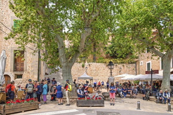 Many tourists in the square with outdoor restaurants in Fornalutx an old idyllic village in Mallorca, Fornalutx, Mallorca, Spain
