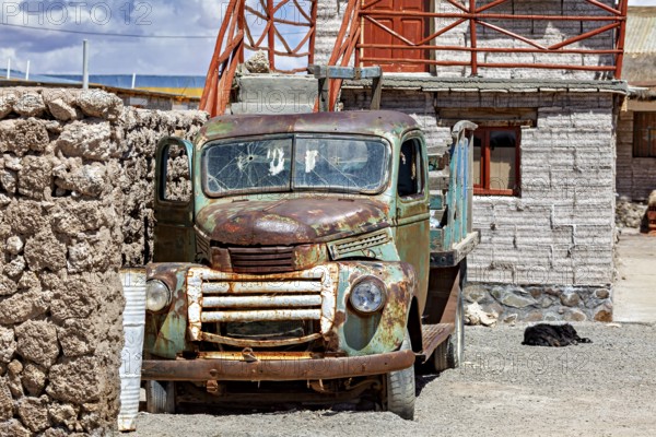 Abandoned rusty lorry in front of a stone building in a peaceful desert landscape, Old lorry in a village on the edge of the Salar de Uyuni in Bolivia