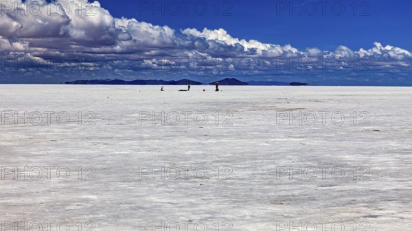 Vast salt desert with small animal-like creatures and clouds in the blue sky, The endless expanses of the salt plain of the Salar de Uyuni in Bolivia