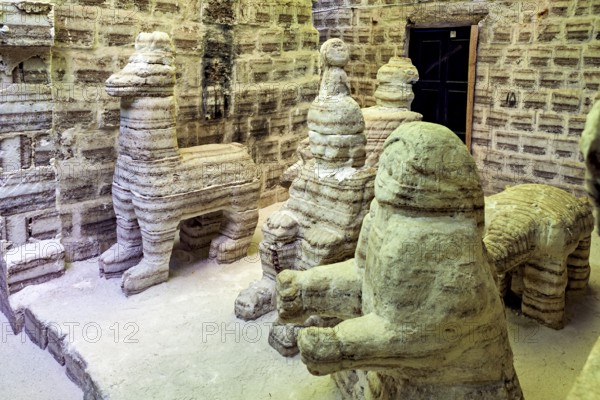 Beige stone sculptures of animals in a rustic room with patterned brick walls, The salt hotel in the salt plain of the Salar de Uyuni in Bolivia