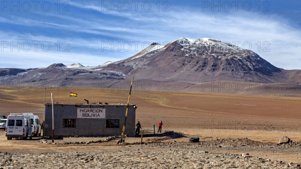 A small migration building in a barren desert landscape with mountains in the background, The small customs station between Chile and Bolivia in the mountains of the Altiplano in Bolivia