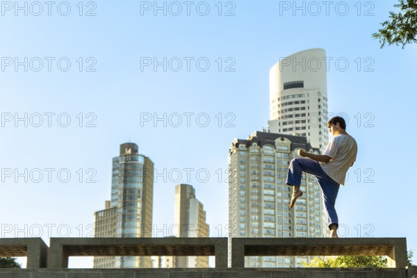 Young martial artist practicing a Taekwondo kick in the city