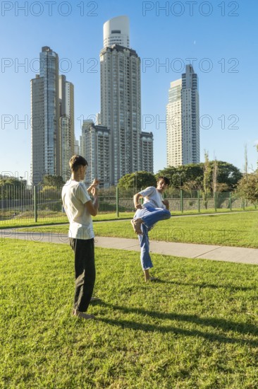 Two young men performing a martial arts drill outdoors
