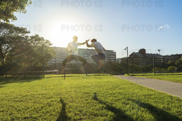 Synchronized martial arts jumps in a sunny park
