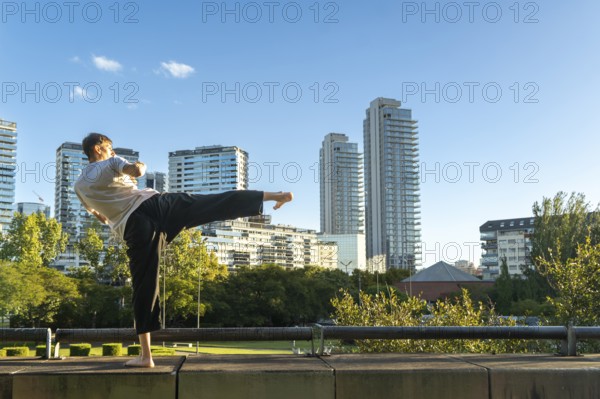 A focused Taekwondo practitioner against a modern city skyline