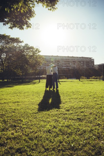 Young men silhouetted by bright sunlight after an outdoor martial arts training session