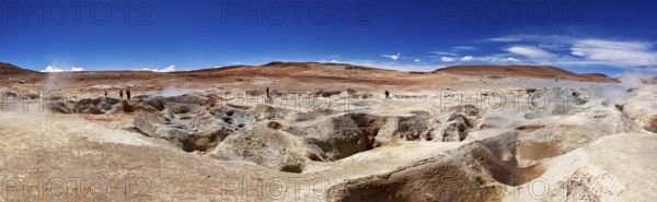 Panoramic view of a geyser field in a barren desert landscape under a bright blue sky, The mud volcanoes and fumaroles on the Altiplano in Bolivia