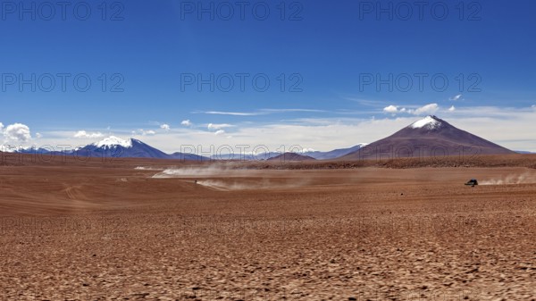 A vast and unspoilt desert landscape with high mountains in the background under a clear sky, The landscape of the Altiplano in Bolivia