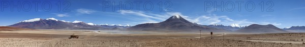 Panoramic view of arid desert and massive, snow-capped mountains, The landscape of the Altiplano in Bolivia