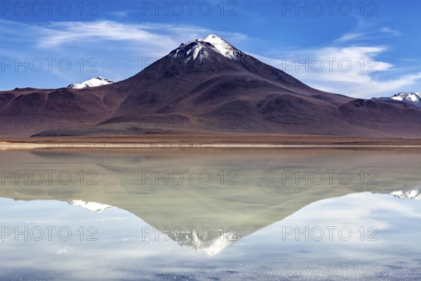 Majestic volcano reflected in a calm lake under a radiant sky, The Laguna Colorada in Bolivia