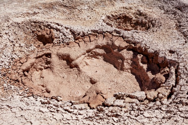 Large geothermal crater with dried mud and cracks, The mud volcanoes and fumaroles on the Altiplano in Bolivia