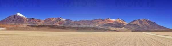 Sweeping panoramic views of a series of mountains, including snow-capped peaks, under a clear sky, The landscape of the Altiplano in Bolivia