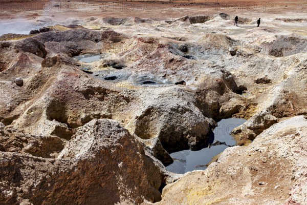 Hot springs with mineral colours in a desert, group of people in the background, The mud volcanoes and fumaroles on the Altiplano in Bolivia