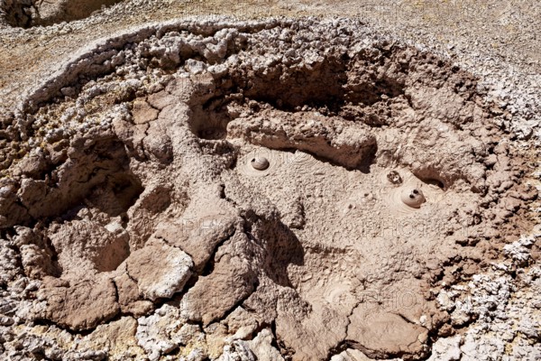 Red, cracked crater with muddy bubbles in a barren environment, The mud volcanoes and fumaroles on the Altiplano in Bolivia