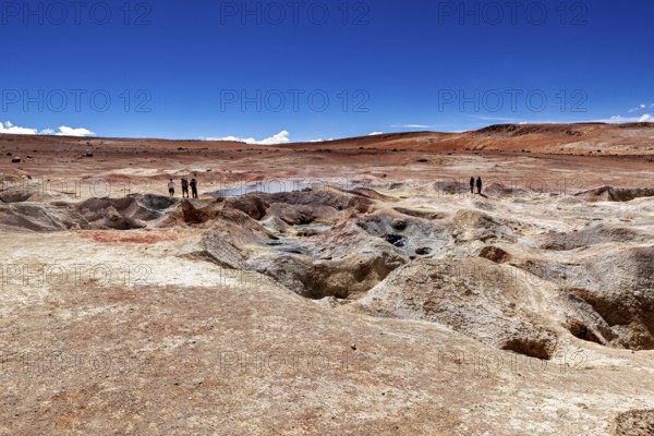 A glistening sky over vast desert plains with geysers and people in the distance, The mud volcanoes and fumaroles on the Altiplano in Bolivia
