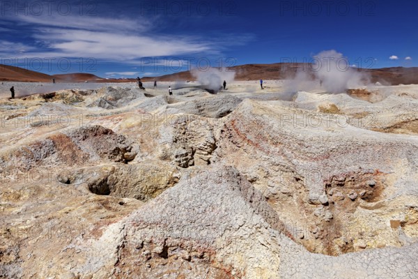 Steam rises from craters in a vast geothermal desert landscape, the mud volcanoes and fumaroles on the Altiplano in Bolivia