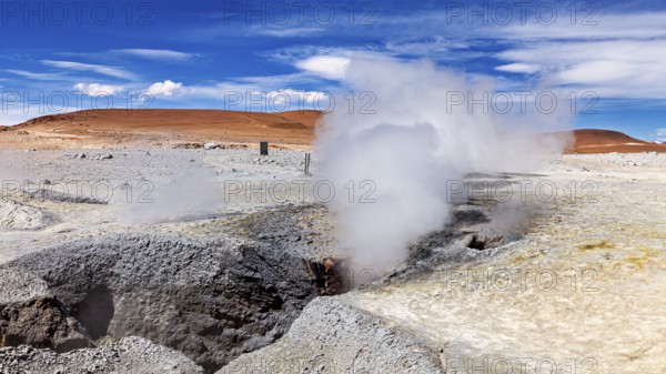 Steam rises from geysers in a rocky desert landscape, sweeping views into the distance, The mud volcanoes and fumaroles on the Altiplano in Bolivia